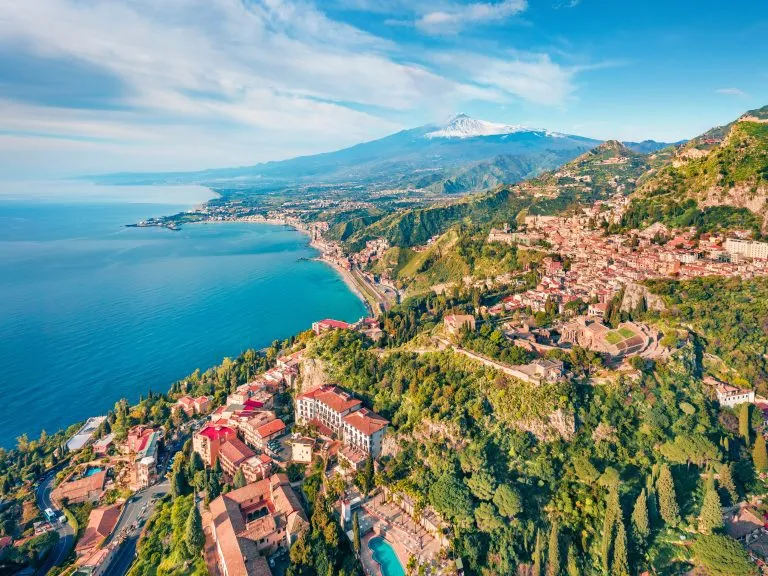 Uitzicht vanuit vliegende drone. Zonnig ochtendzicht op de stad Taormina en de vulkaan Etna op de achtergrond. Mooi lentegezicht op de Middellandse Zee. Prachtig uitzicht op Sicilië, Itale, Europa.